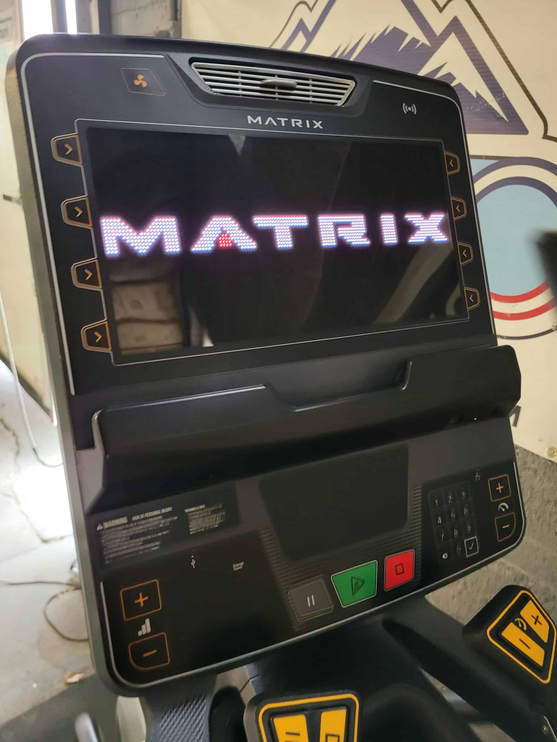 High-tech treadmill with illuminated "Matrix" logo, digital display, and control panel, suitable for advanced cardio and fitness training.