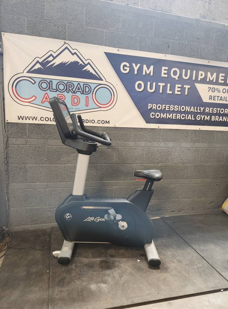 Indoor gym exercise bike at Colorado Cardio fitness outlet with promotional banner in the background.