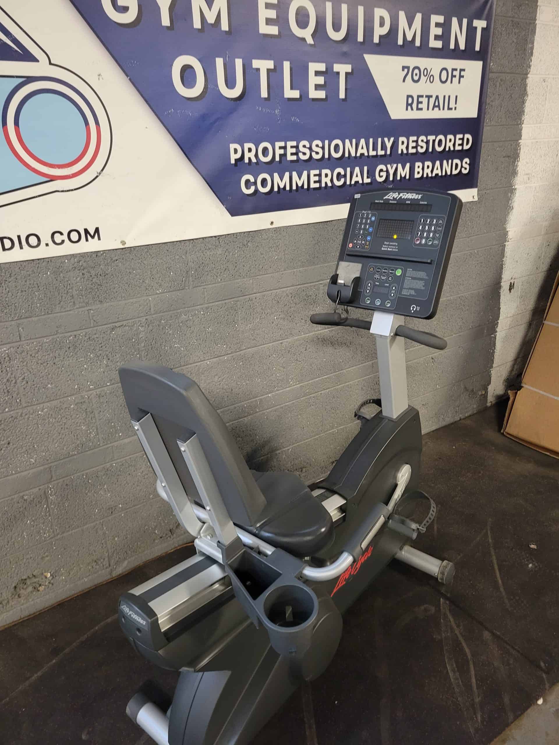 Exercise bike in a fitness equipment outlet promoting commercial gym brands and discounts for health and cardio fitness.